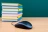 Computer mouse and group of books on desk.